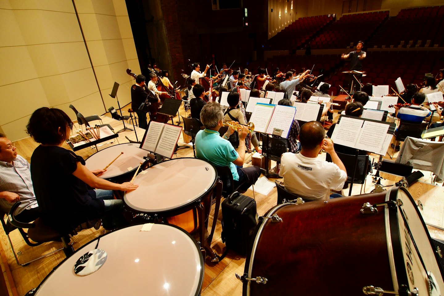 Musicisti suonano strumenti durante una prova d'orchestra sul palco.