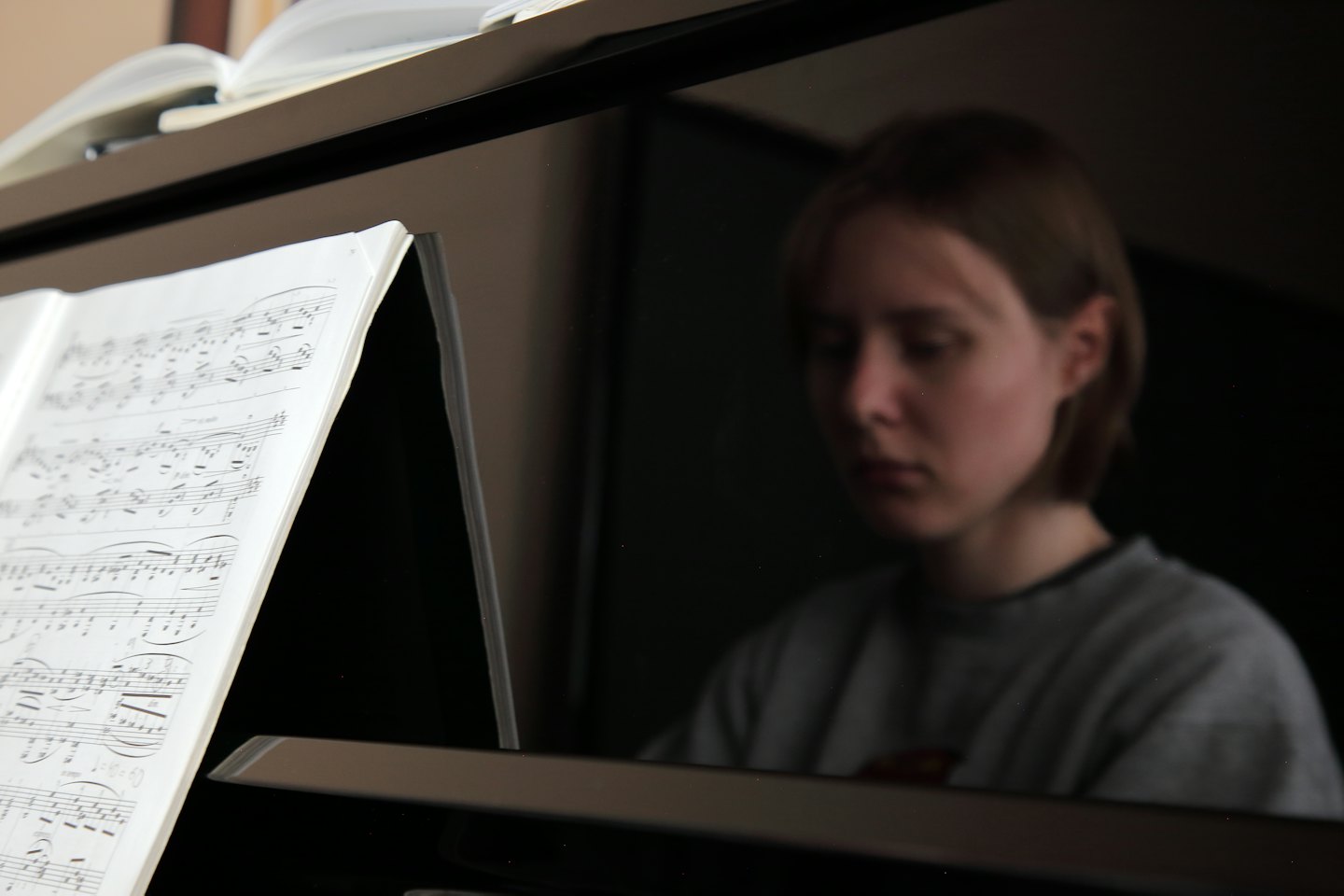 Spartito aperto su un pianoforte nero lucido.